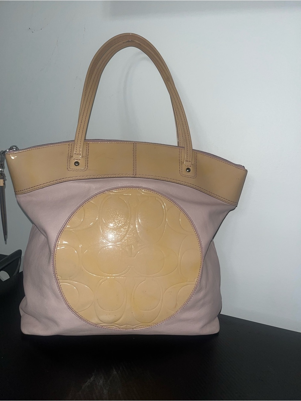 Coach Signature Laura Tote features a large circular embossed leather patch